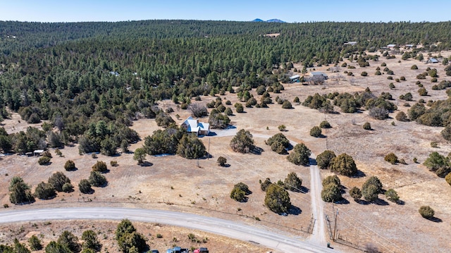 drone / aerial view featuring a wooded view