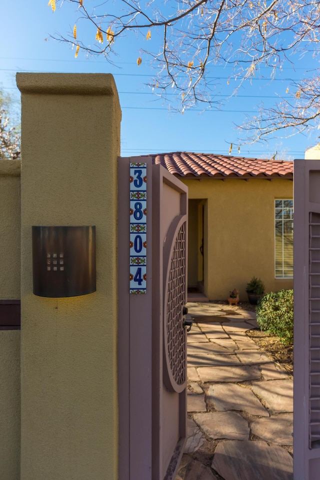 exterior details with a tile roof and stucco siding