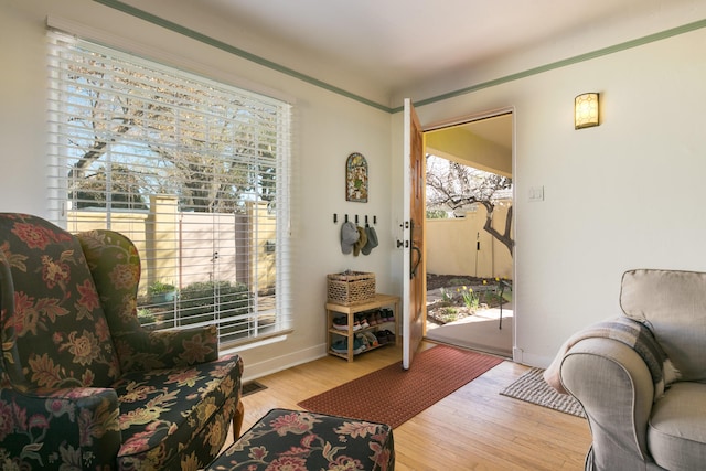 living area with visible vents, baseboards, and wood finished floors