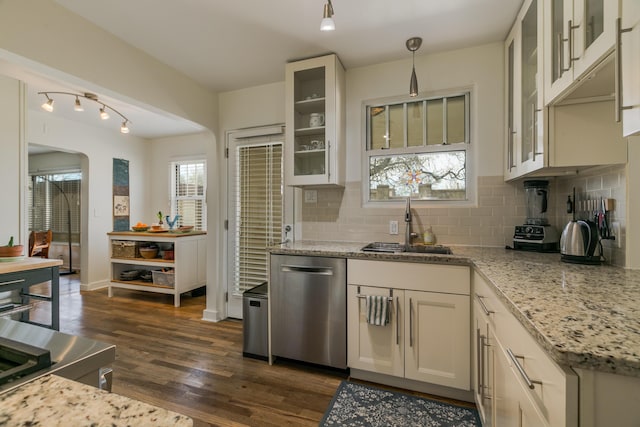 kitchen with stainless steel dishwasher, dark wood-style flooring, backsplash, and a sink