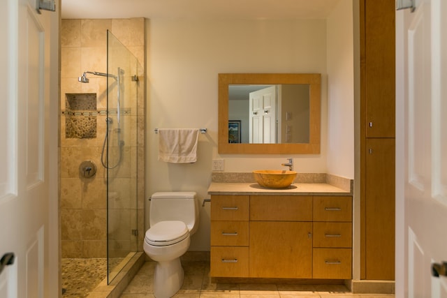 bathroom with tile patterned floors, a shower stall, toilet, and vanity