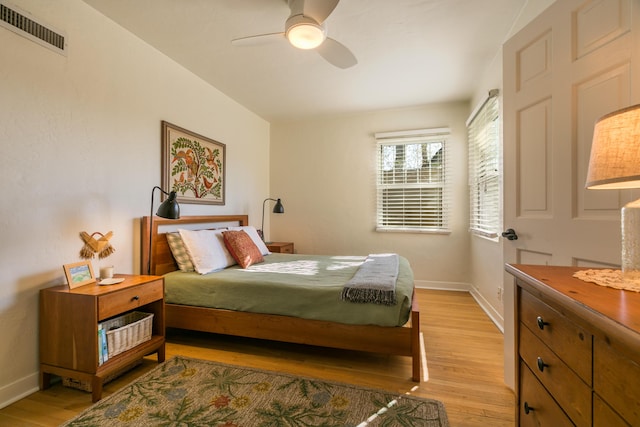 bedroom featuring a ceiling fan, light wood-style flooring, baseboards, and visible vents