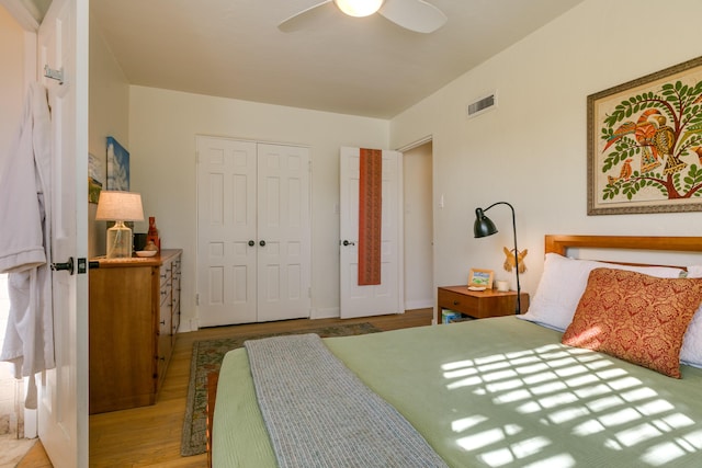 bedroom with a closet, a ceiling fan, visible vents, and light wood finished floors