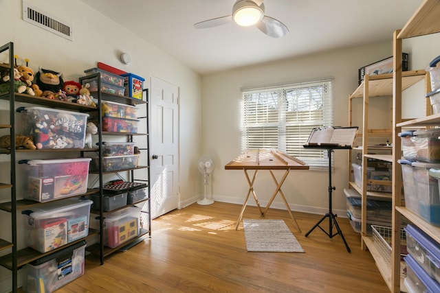 office space with visible vents, baseboards, a ceiling fan, and wood finished floors