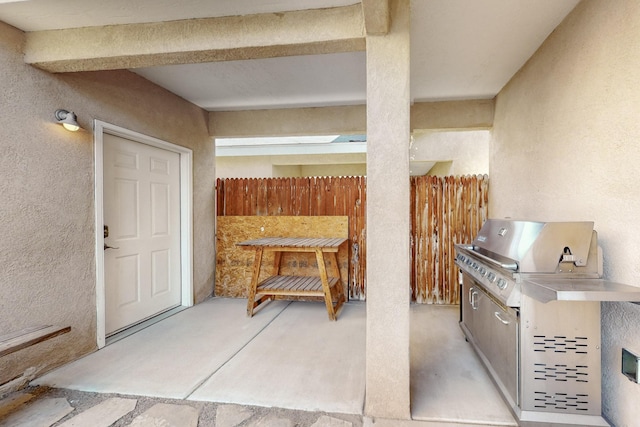 view of patio with fence and a grill