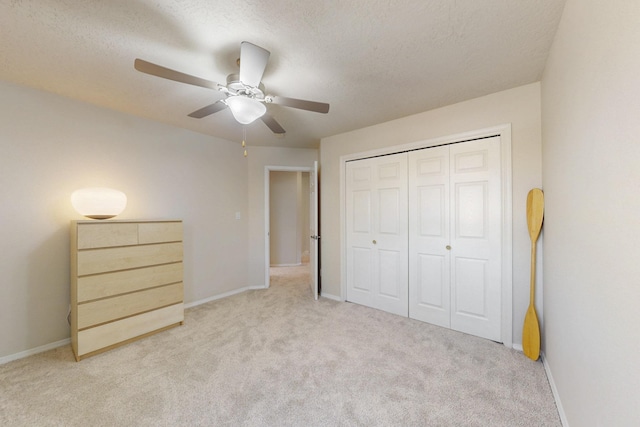 unfurnished bedroom featuring carpet flooring, baseboards, a closet, and a textured ceiling