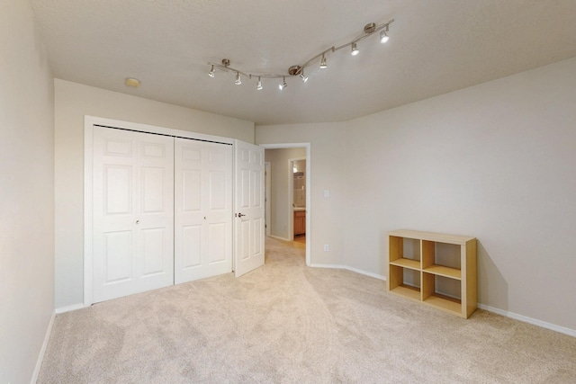 unfurnished bedroom with a closet, baseboards, and carpet flooring