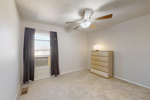 unfurnished room featuring cooling unit, visible vents, ceiling fan, a textured ceiling, and carpet flooring