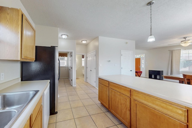 kitchen featuring pendant lighting, a sink, white dishwasher, light countertops, and ceiling fan