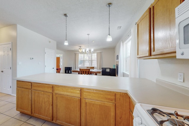 kitchen with a notable chandelier, white appliances, a textured ceiling, and light countertops