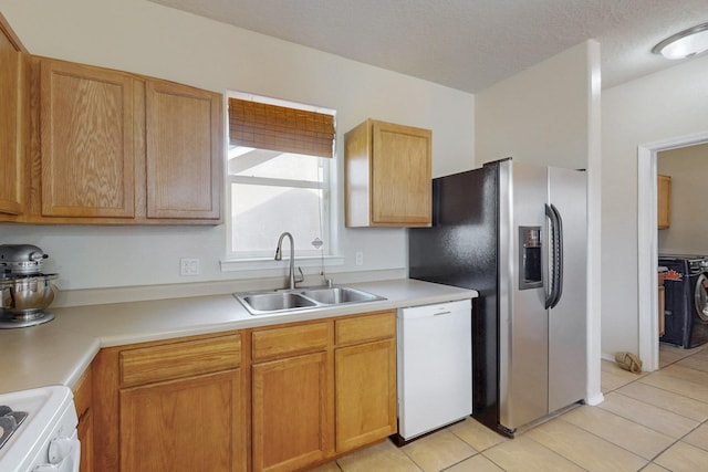 kitchen featuring light tile patterned floors, white dishwasher, a sink, stove, and light countertops