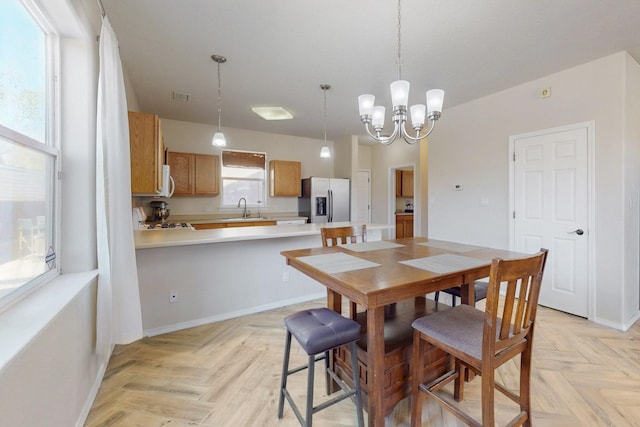 dining space featuring a notable chandelier, baseboards, and visible vents