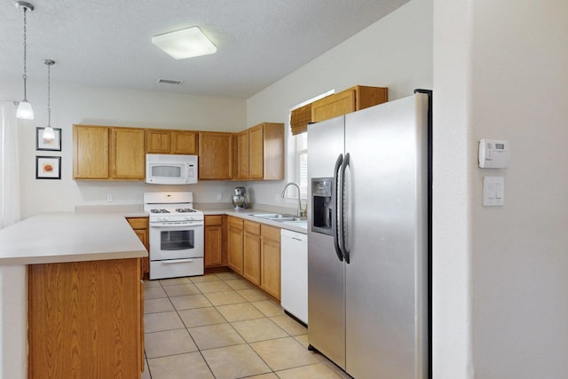 kitchen featuring visible vents, a sink, white appliances, a peninsula, and light tile patterned flooring