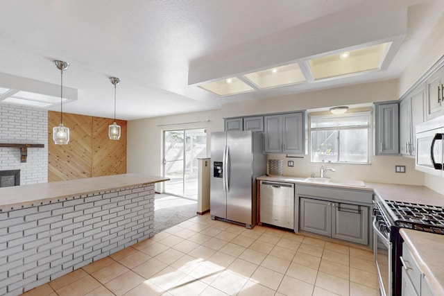 kitchen with gray cabinets, stainless steel appliances, and a sink