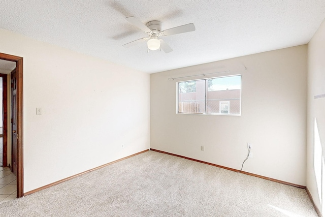 unfurnished room featuring baseboards, light colored carpet, a textured ceiling, and a ceiling fan