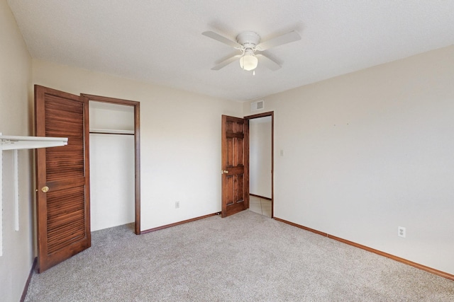 unfurnished bedroom featuring visible vents, a ceiling fan, a closet, carpet, and baseboards