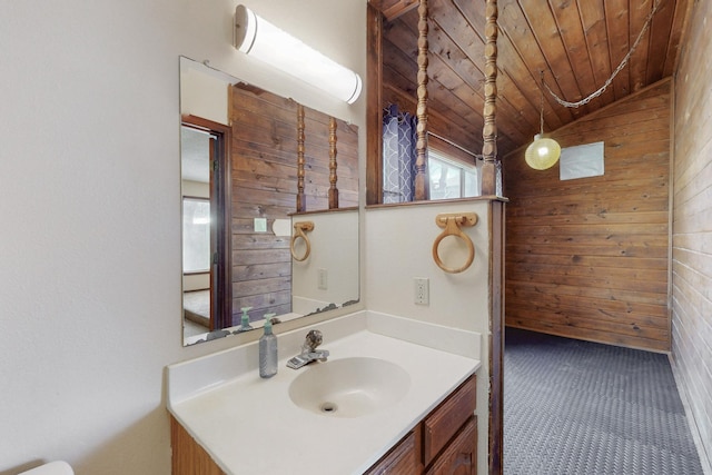 bathroom featuring wood walls, wood ceiling, vanity, and vaulted ceiling