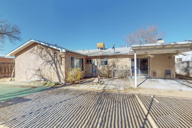 back of house with a patio area, fence, and stucco siding