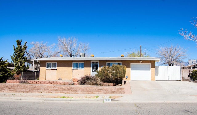 ranch-style home with driveway, a gate, fence, a garage, and brick siding