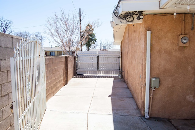 view of patio featuring fence and a gate