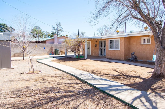 view of front of home featuring stucco siding and fence