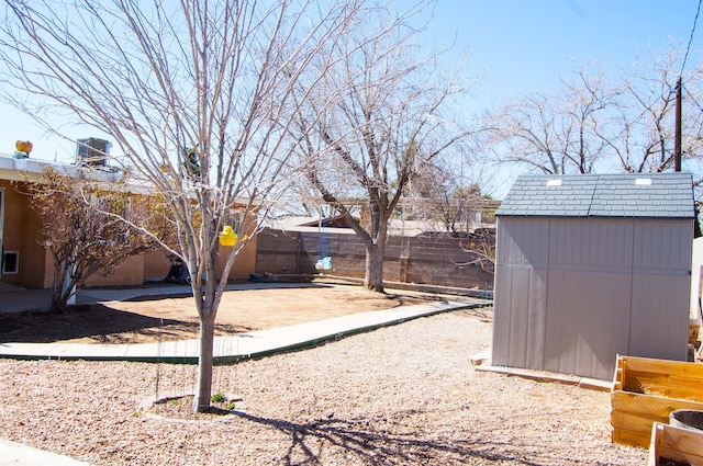 view of yard with an outbuilding, a fenced backyard, a shed, and a patio area