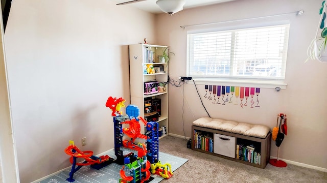 rec room featuring baseboards, carpet, and a ceiling fan