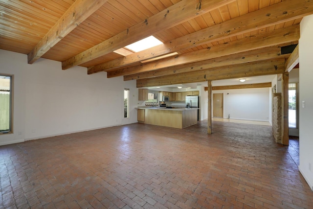 unfurnished living room featuring brick floor, wooden ceiling, beamed ceiling, and baseboards