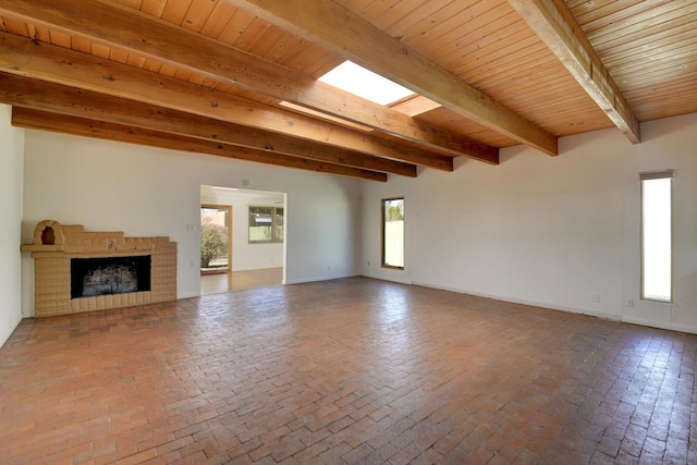 unfurnished living room featuring beam ceiling, wooden ceiling, a fireplace, and brick floor