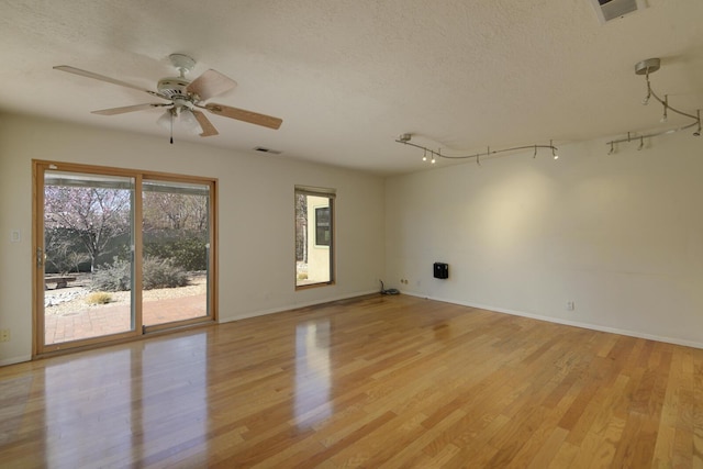 unfurnished room with visible vents, light wood-style flooring, a textured ceiling, and ceiling fan