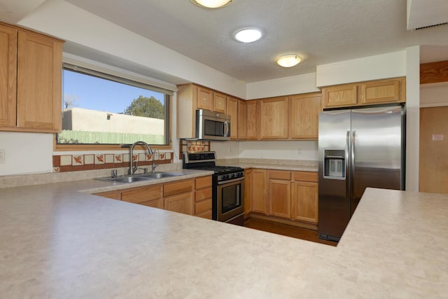 kitchen featuring a sink, appliances with stainless steel finishes, and light countertops