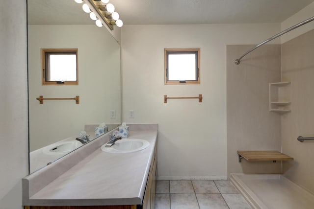 bathroom with plenty of natural light, walk in shower, vanity, and tile patterned flooring