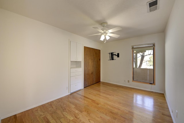 unfurnished bedroom with light wood-type flooring, visible vents, a closet, baseboards, and ceiling fan