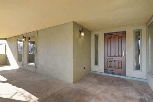 doorway to property featuring stucco siding