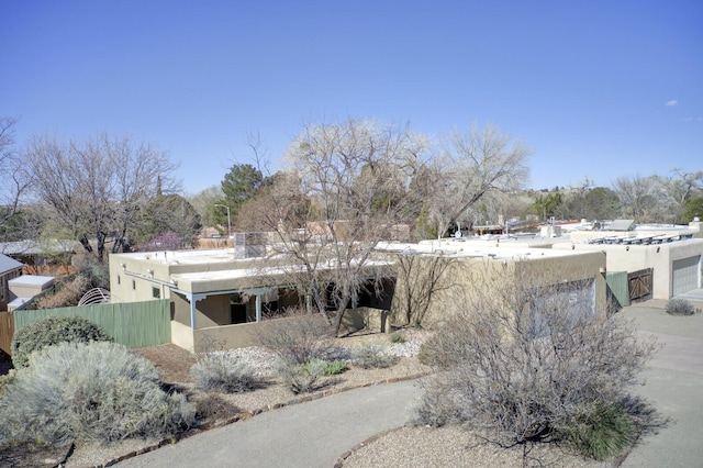 exterior space with stucco siding and fence