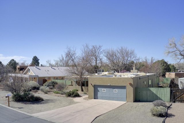 view of front of house with a gate, fence, stucco siding, concrete driveway, and a garage