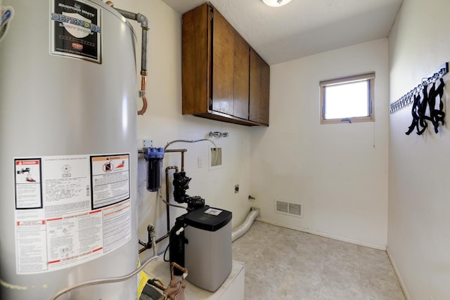 utility room featuring gas water heater and visible vents