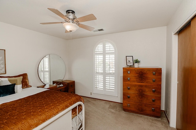 bedroom with ceiling fan, visible vents, and light carpet