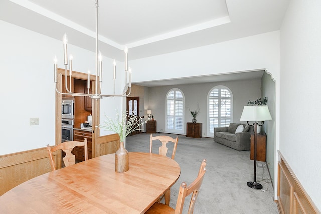 carpeted dining space featuring a raised ceiling