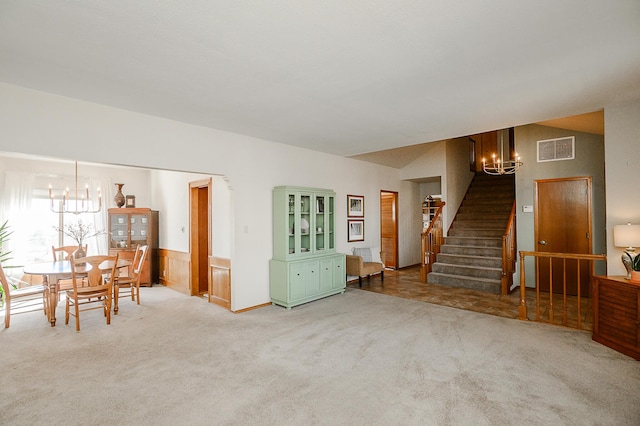 unfurnished dining area with stairway, a notable chandelier, and carpet