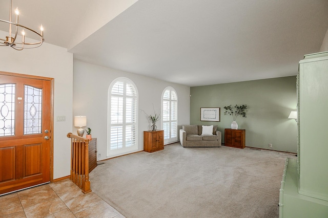 carpeted entryway with tile patterned floors, a notable chandelier, and baseboards