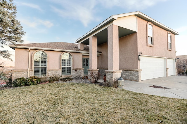 view of front of house with stucco siding, a front lawn, concrete driveway, a garage, and brick siding