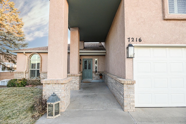 entrance to property featuring stone siding, stucco siding, and roof with shingles