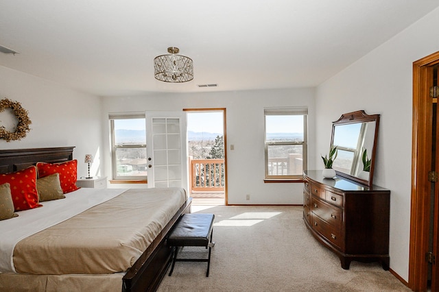 bedroom with light carpet, multiple windows, baseboards, and access to outside