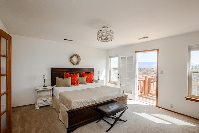 carpeted bedroom with visible vents, multiple windows, and baseboards