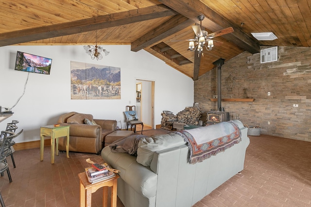 living room featuring wood ceiling, beam ceiling, a wood stove, brick floor, and a ceiling fan