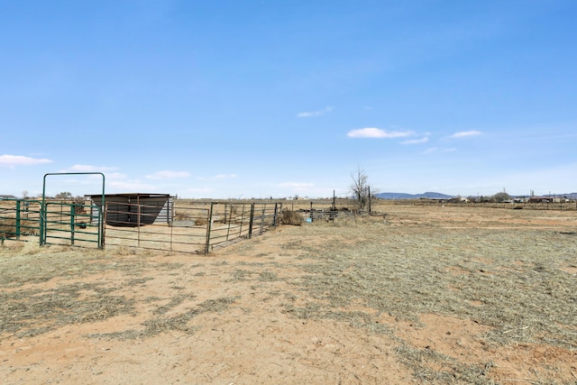 view of yard featuring an outbuilding, a rural view, and an exterior structure