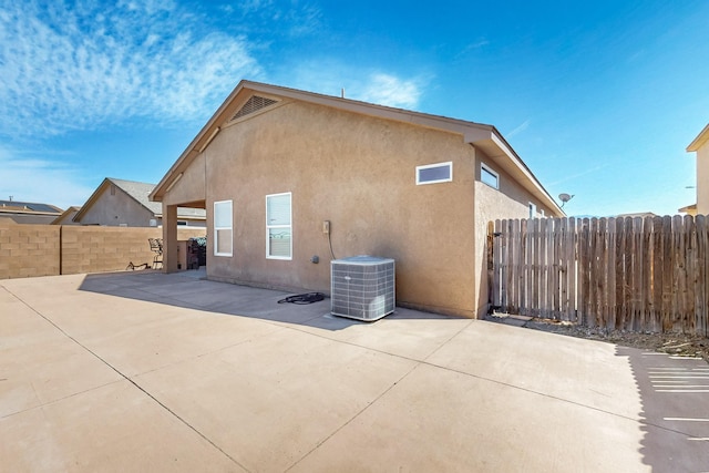 back of house with a patio area, central air condition unit, stucco siding, and fence