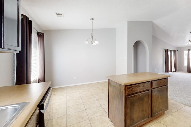 kitchen featuring vaulted ceiling, light tile patterned floors, visible vents, and dishwashing machine