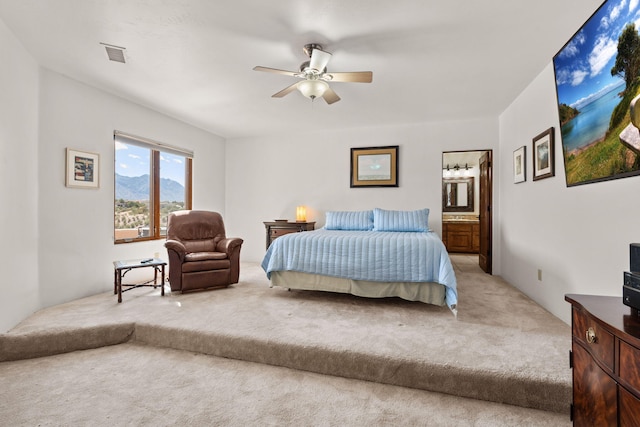 bedroom featuring connected bathroom, a ceiling fan, carpet flooring, and visible vents